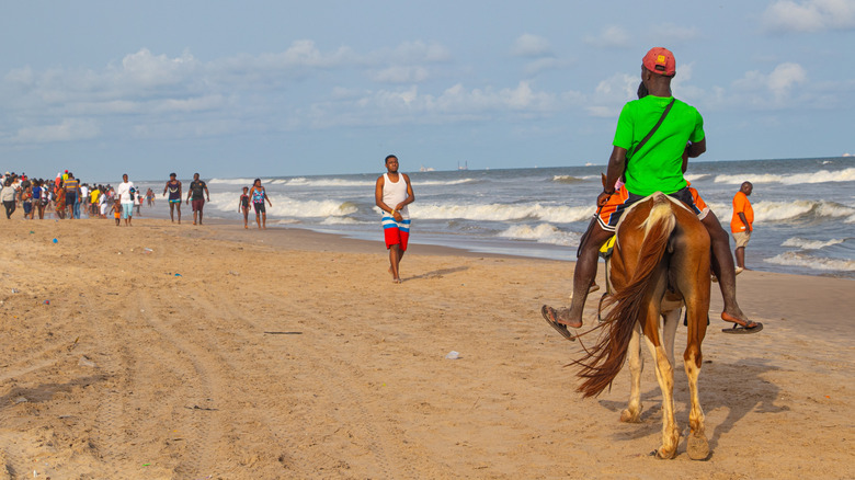 Local man riding a horse at Labadi Beach in Accra, Ghana
