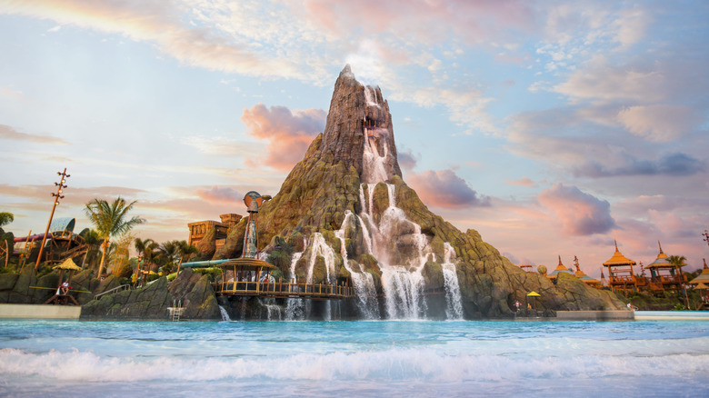 Sunset view of Krakatau volcano, a 200-foot human-made structure, and the surrounding water and attractions at Volcano Bay
