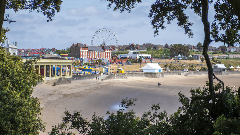 View of Whitmore Bay Beach and promenade in Barry, Wales between trees