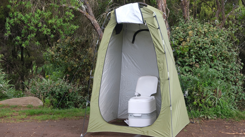 A portable toilet in a pop-up tent outdoors