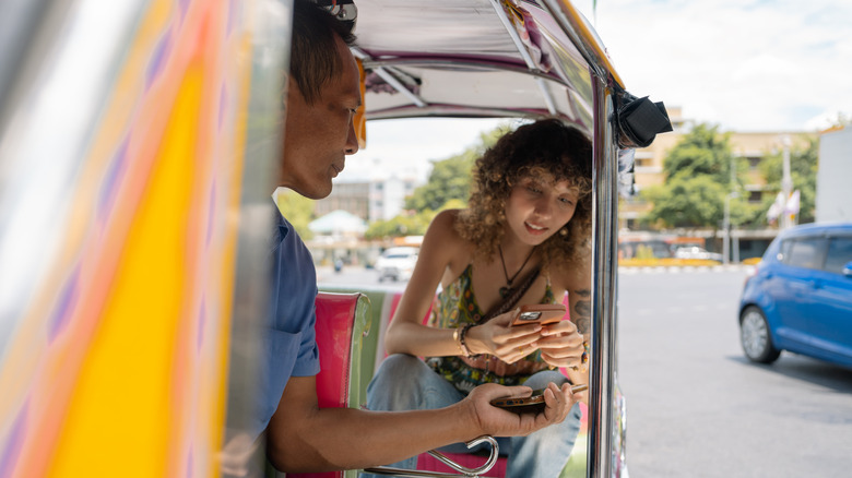 A tourist talking with a tuk-tuk driver