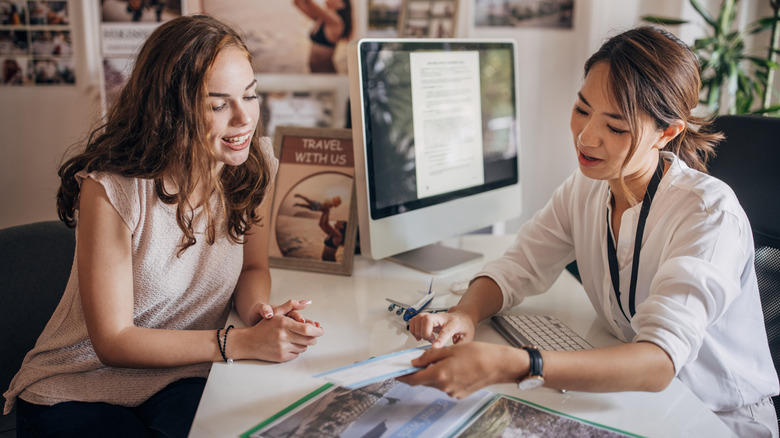 A female customer consults with a travel agent.