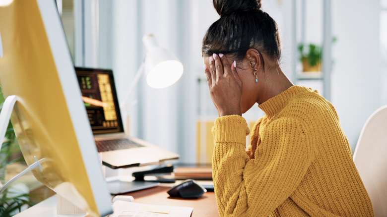 A frustrated young woman in front of a computer