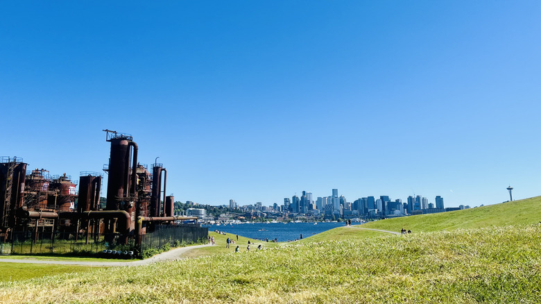 A gasification plant on a grassy hill overlooks Lake Union and the Seattle skyline.