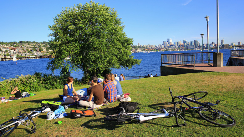 A group of friends relaxes on the grassy shores of Lake Union at Gas Works Park in Seattle.