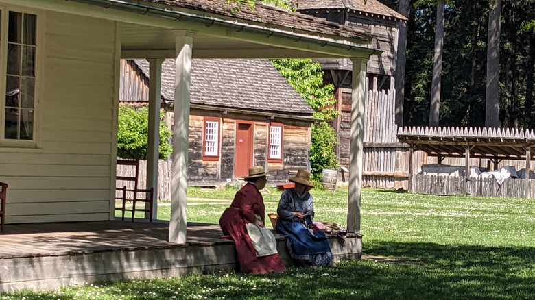 Two reenactors dressed in traditional colonial women's garb at Fort Nisqually in Washington