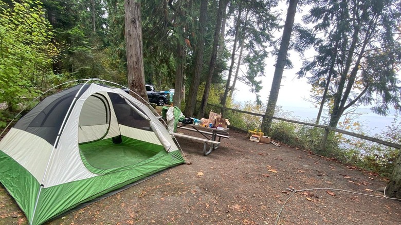 A green and white tent with camping set up overlooking the Puget Sound at Sequim Bay State Park, in Washington.
