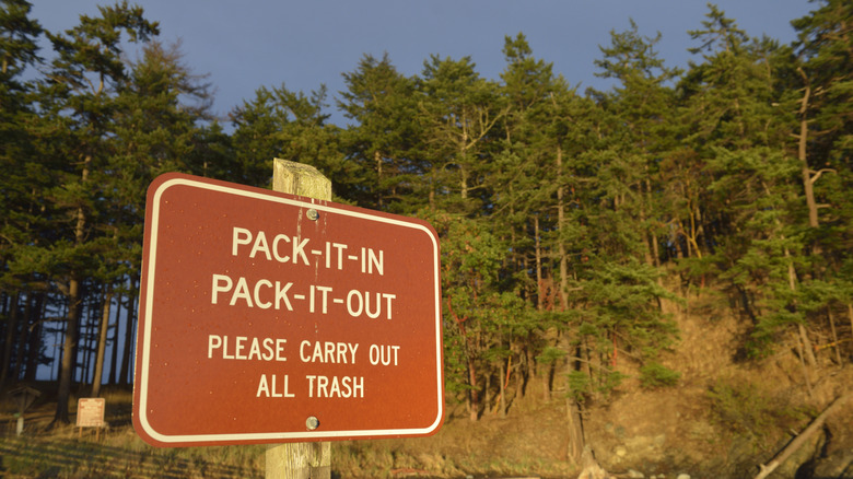 A sign reading "CARRY OUT ALL TRASH" at James Island Marine State Park, Washington.