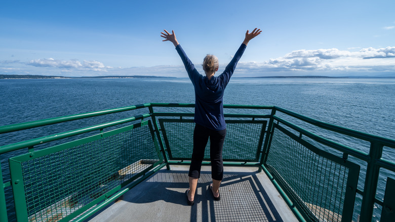 Woman with arms raised on a ferry