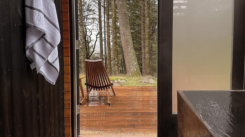 View on a rainy day across a deck with an onsen-inspired infinity tub