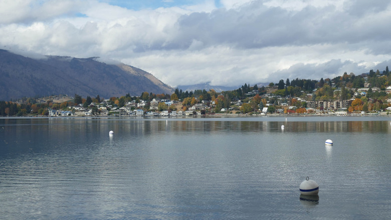 Lake view of Manson, Washington with overcast skies, and mountains and houses in the background