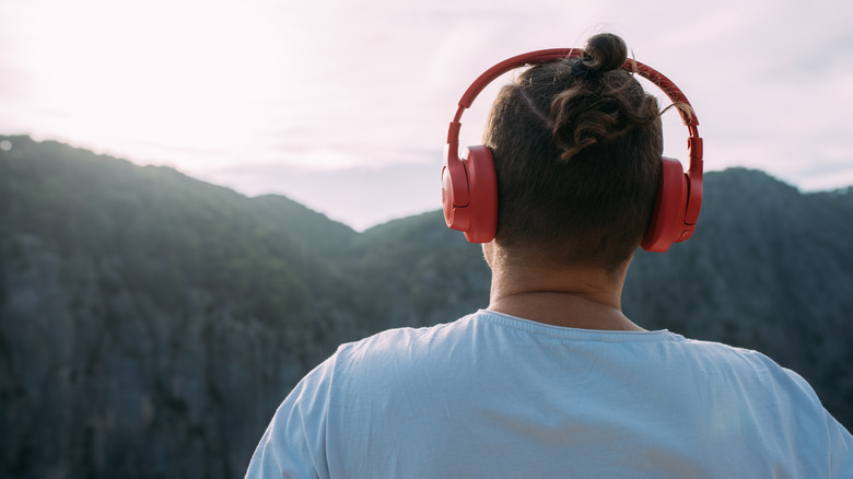 Hiker wearing headphones while admiring mountains