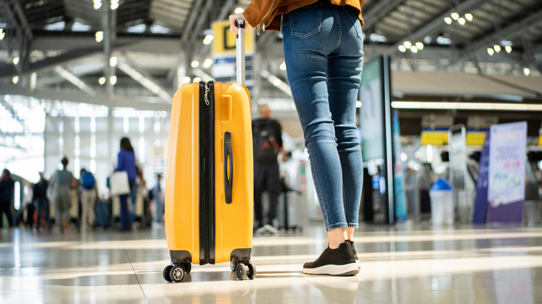 A woman in skinny jeans walks through an airport