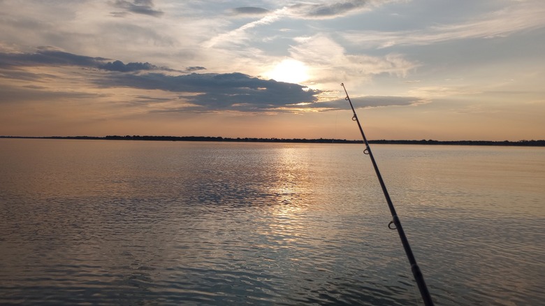 A fishing rod cast into Webster Reservoir during sunset at Webster State Park, Kansas