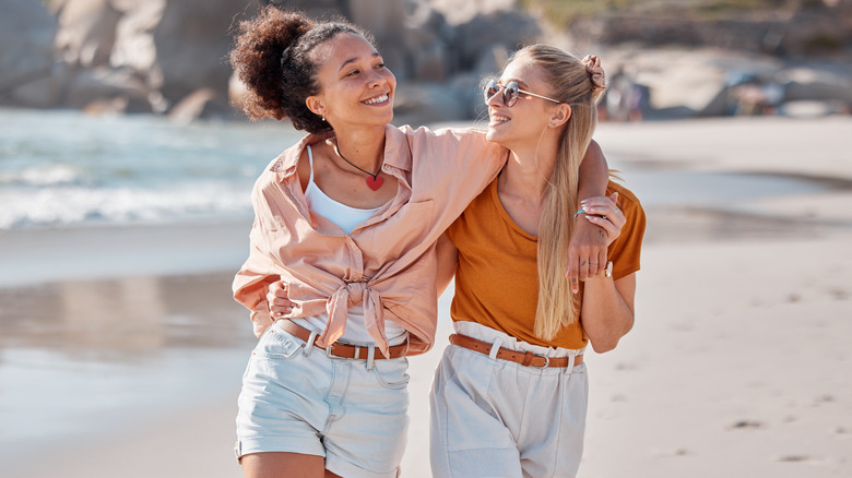 Two women walking on beach