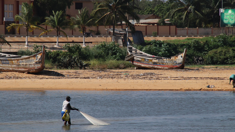 A fisherman casts a net offshore Aného Beach, Togo