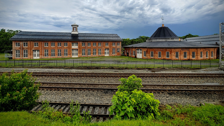 Train tracks with a roundhouse and brick train station