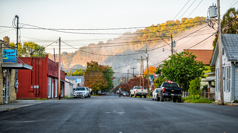 Street in Marlinton, West Virginia lined in buildings, with fog-shrouded autumn hills in the background