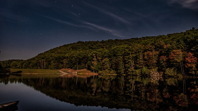 Starry night sky stretches over the calm lake at Watoga State Park, West Virginia
