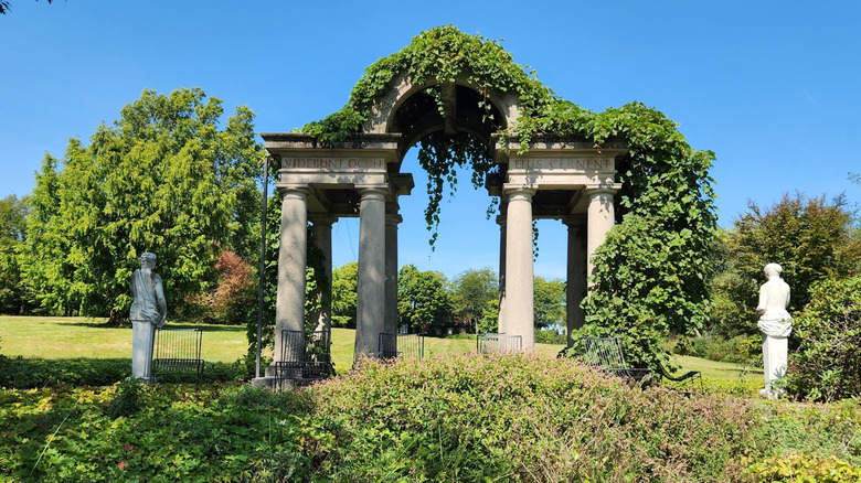 Vine-covered marble arch and statues at the Wethersfield Estate & Garden in New York