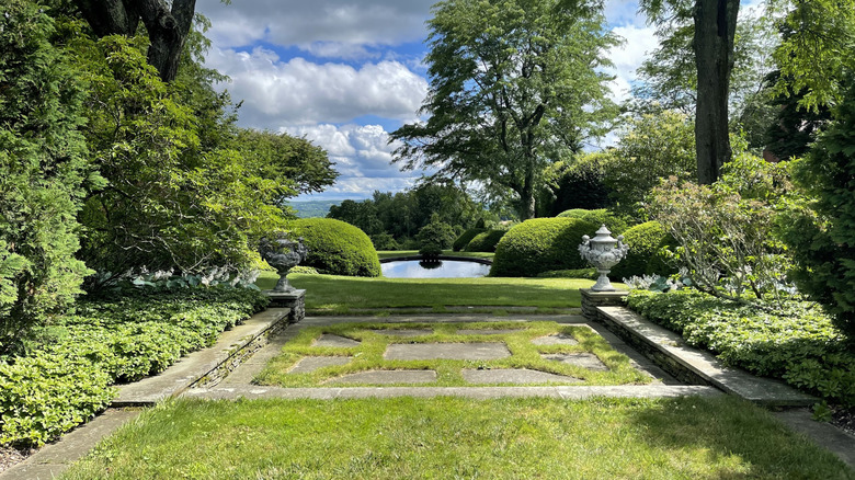 Manicured hedges around a terrace and pool at the Wethersfield Estate & Garden in New York