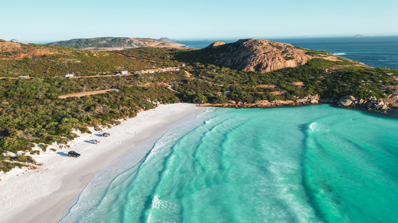 Bluffs and headland around the white sand and turquoise water of Wharton Beach, Australia