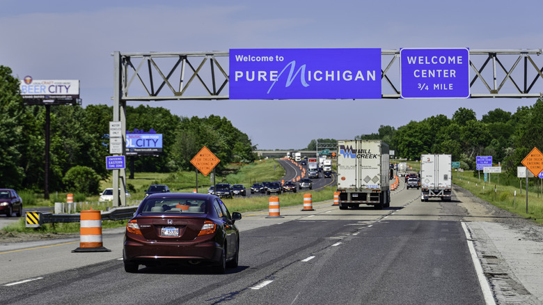 Cars on a highway, with a blue Pure Michigan sign above