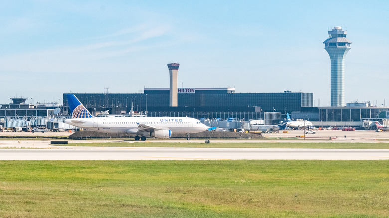 A United Airlines Airbus taxis in front of the Air Traffic Control tower and Airport Hilton hotel at ORD in Chicago