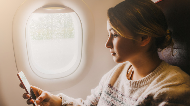 Woman using her phone mid-flight