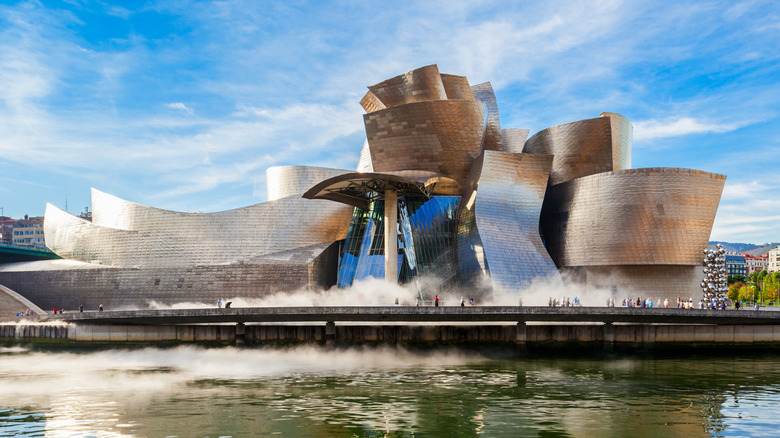 The twisting, warped, and glass exterior of the Bilbao Guggenheim designed by Frank Gehry