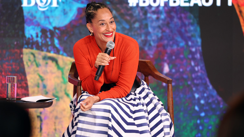 Actress Tracee Ellis Ross smiling with microphone in her hand