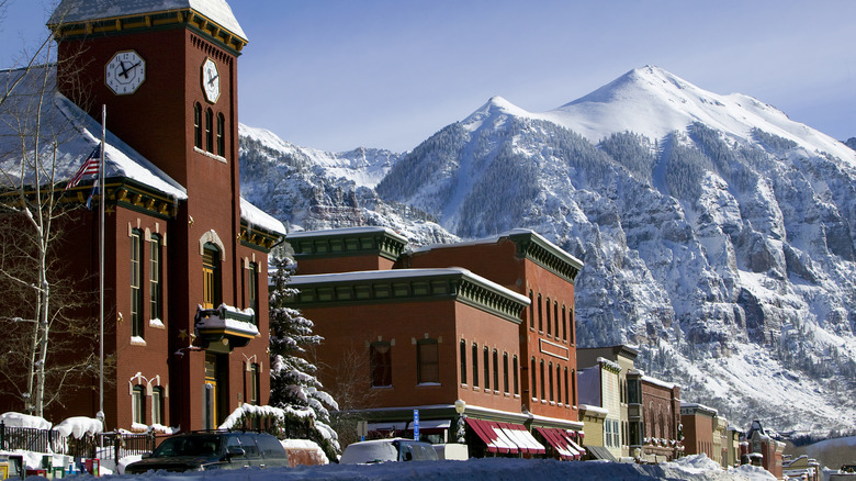 Historic buidlings sit under snowy mountains in the downtown of Telluride
