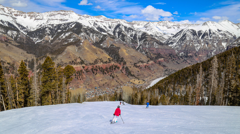 Skiers descend a slope towards the town of Telluride, Colorado