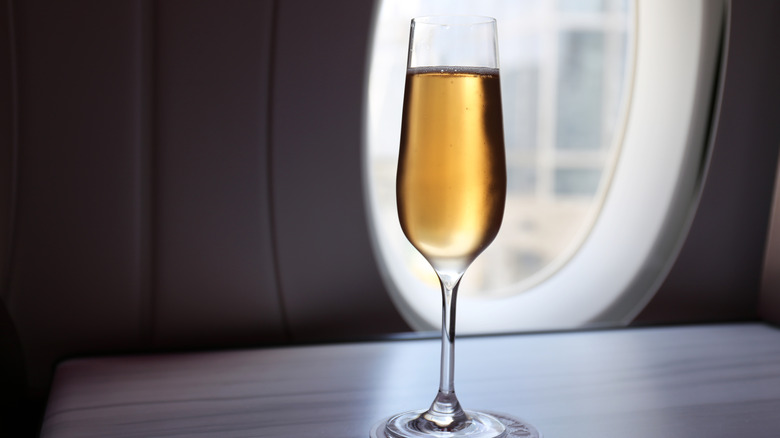 A glass of champagne in a first-class airplane cabin