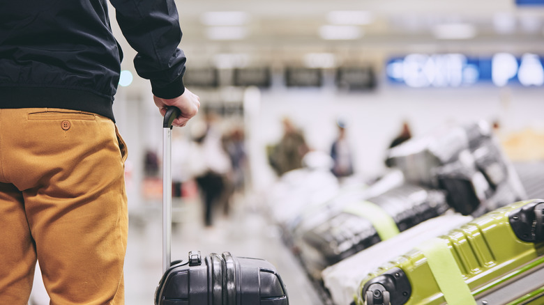 A man waiting at the baggage carousel