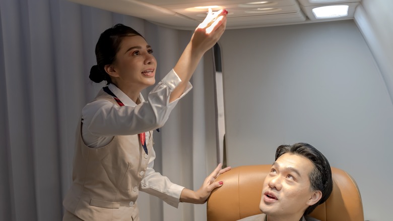 Flight attendant turning off passenger call button