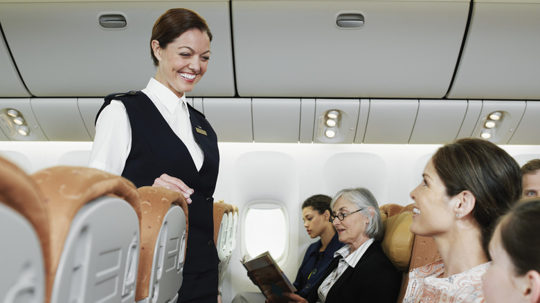 Flight attendant speaking to passengers on a flight