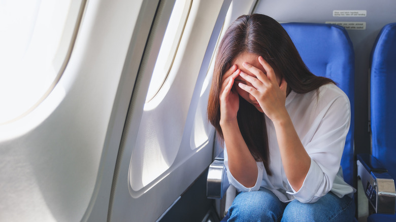 A woman feeling ill on a plane
