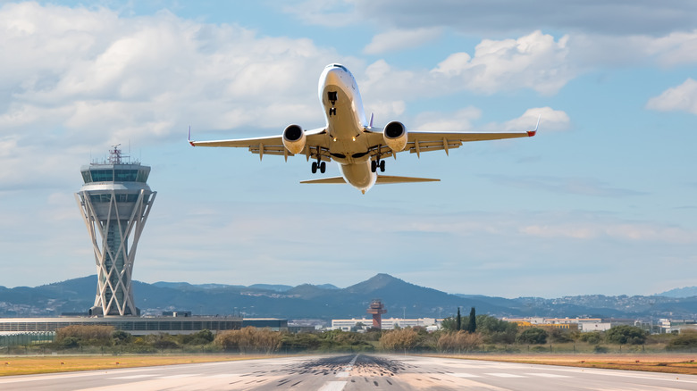 plane takes off over airport runway