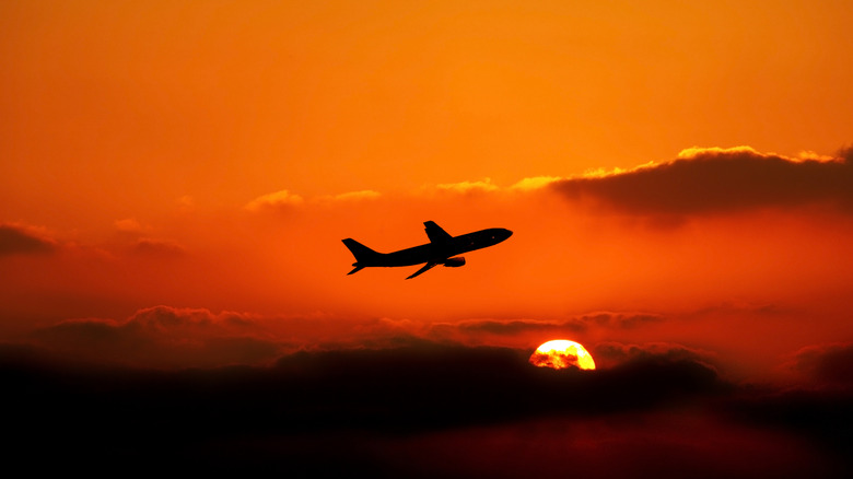 Airplane flying at sunset