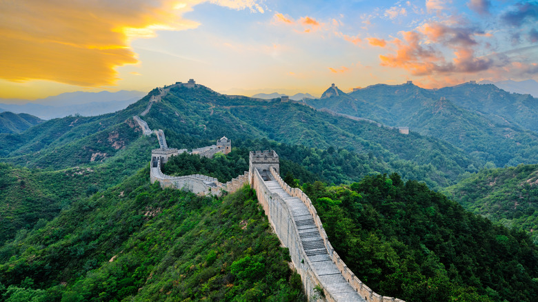 Aerial view of great wall of China with the sun behind the mountains