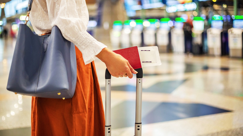 Woman with suitcase and boarding pass