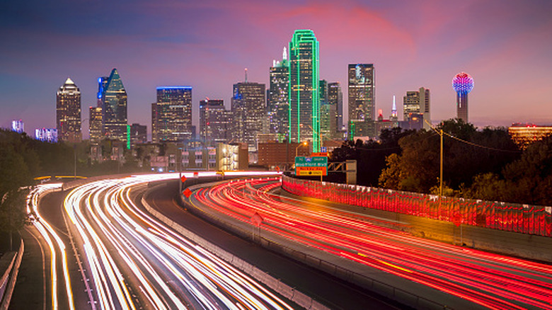 Time lapse of a crowded Dallas freeway at dusk near illuminated downtown skyscrapers