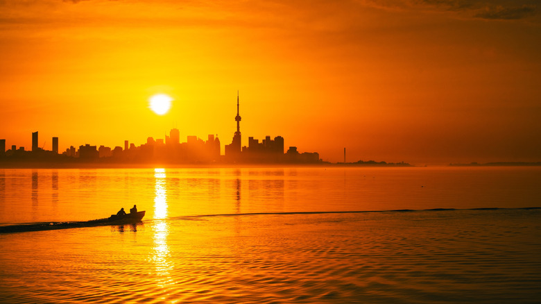 Toronto skyline at sunset in the summertime with a boat on the lake