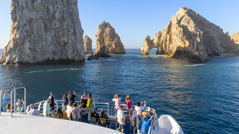 View from boat with tourists looking at rock formations in ocean