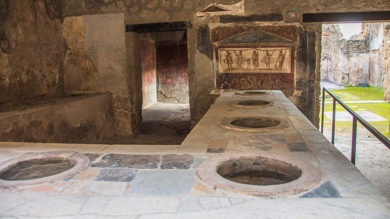 Counter with holes in an ancient thermopolium in Pompeii