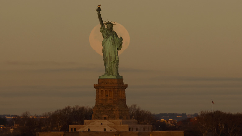 The Statue of Liberty silhouetted by the moon