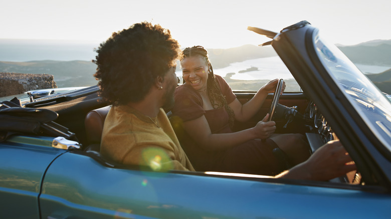 A couple smiling in a convertible