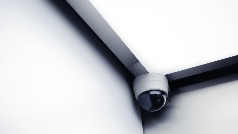 A CCTV surveillance camera mounted in a minimalist ceiling corner