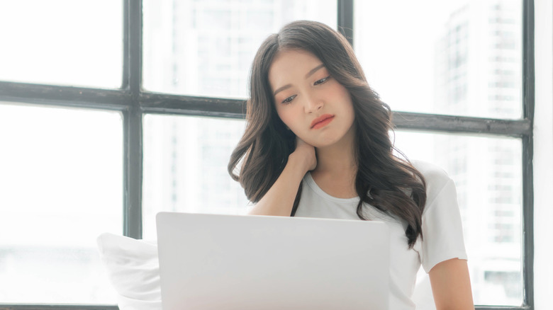 A frustrated woman uses her laptop